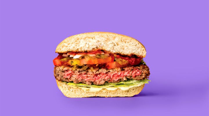 A cross section of a hamburger against a purple backround